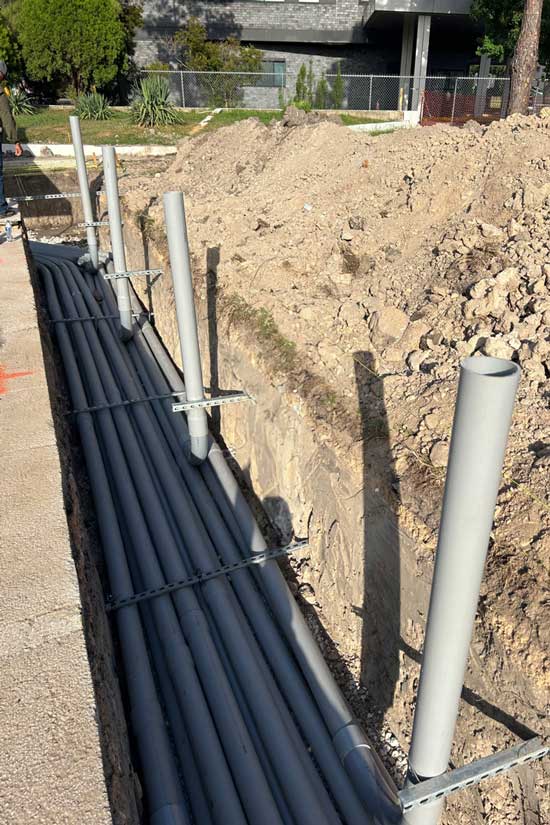 Underground conduit exposed and prepared for EV charging stations.